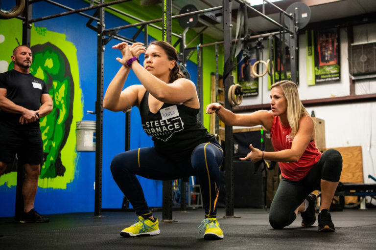 Athlete-Learning-How-to-Squat-With-a-CrossFit-Coach-scaled