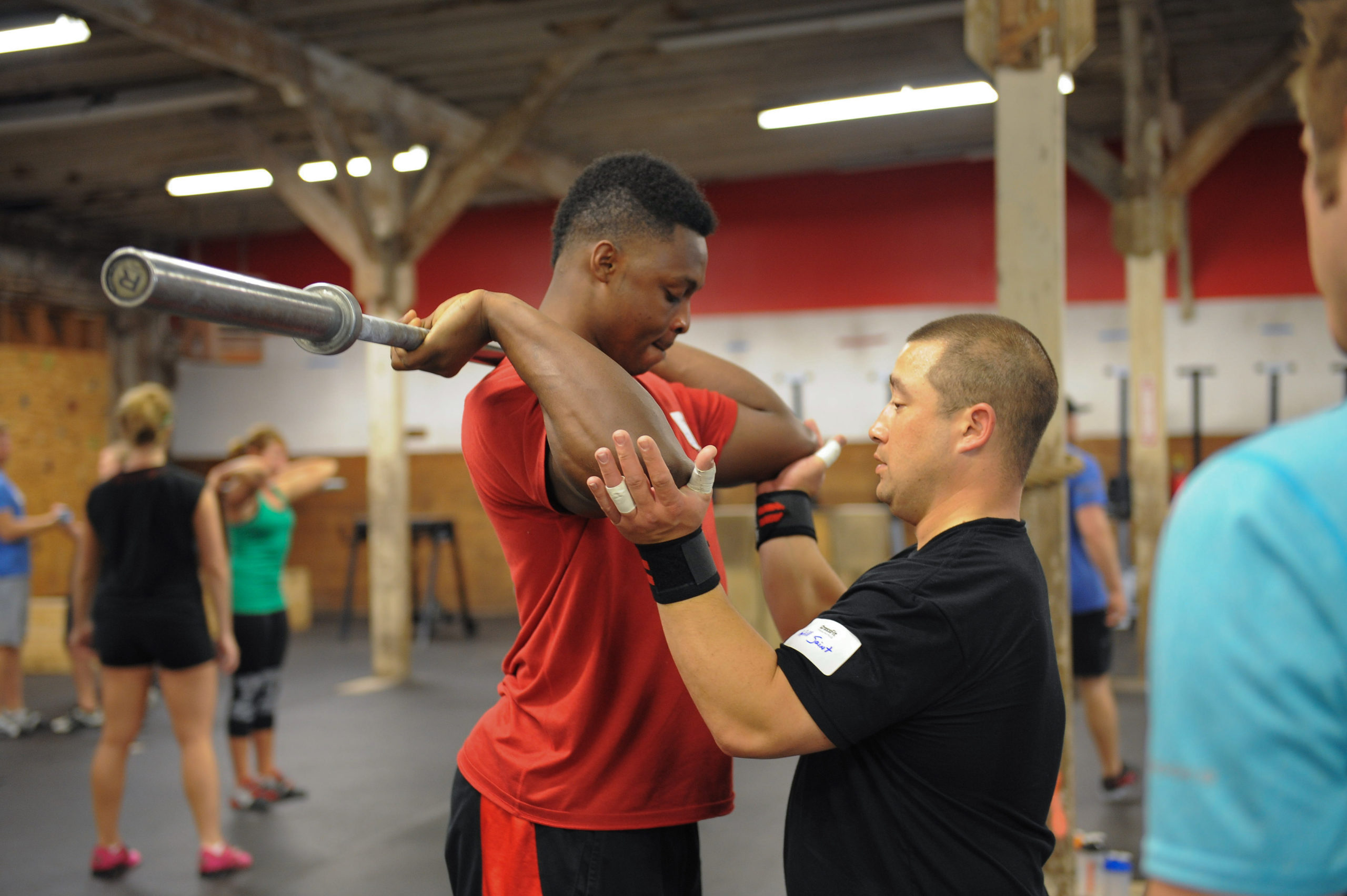 A coach works with a young athlete on front-rack position