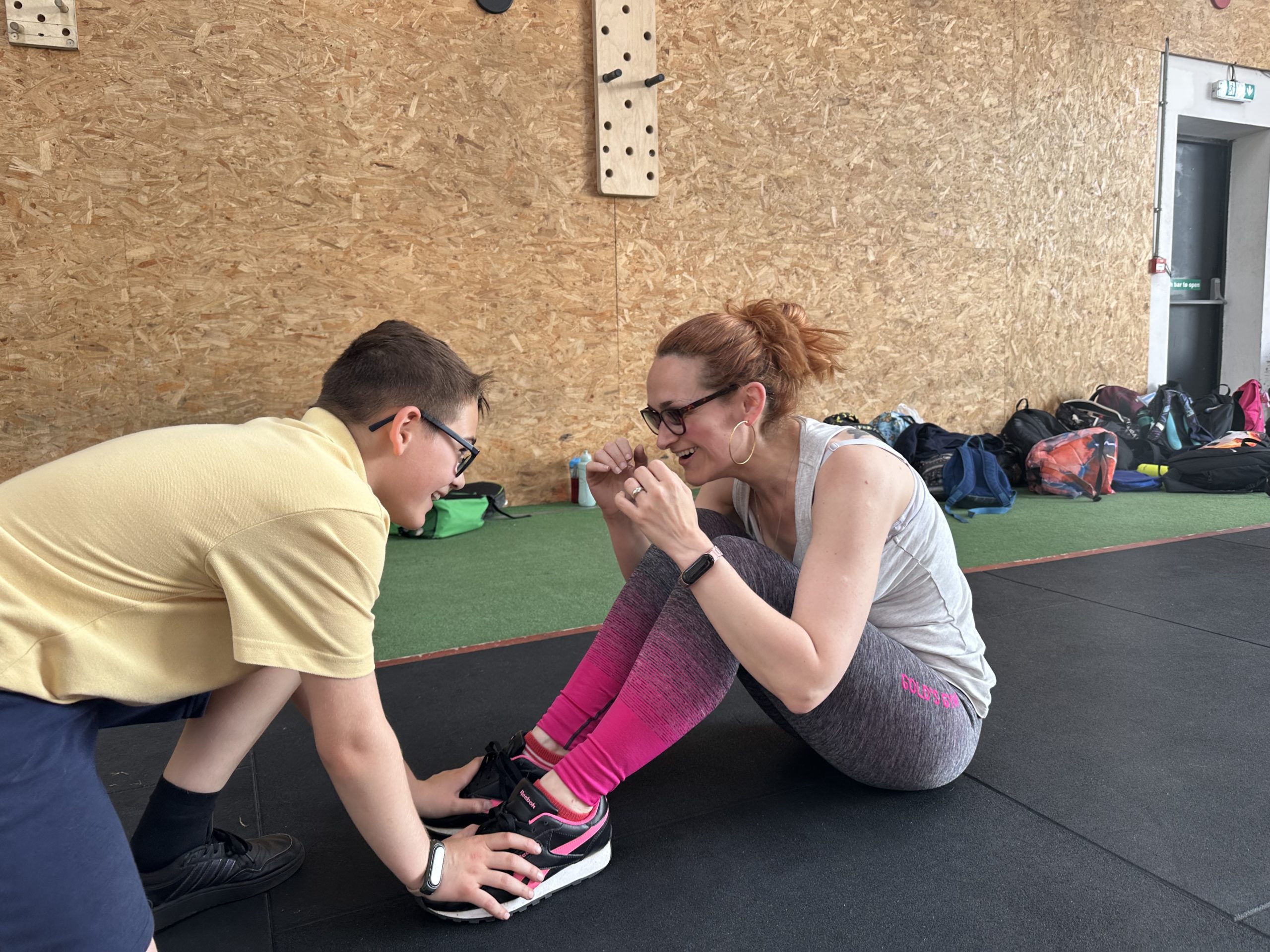 A son assist his mother during a sit-up