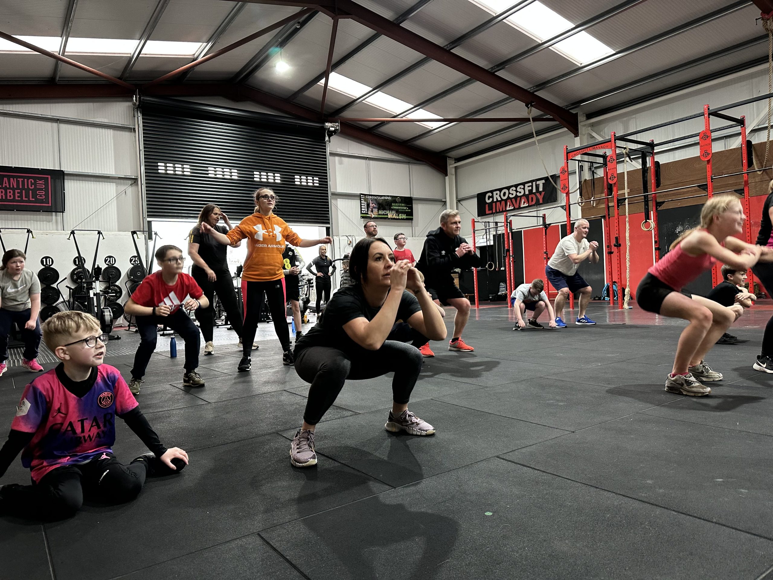 Schoolchildren from Limavady Central Primary School do air squats at Limavady CrossFit