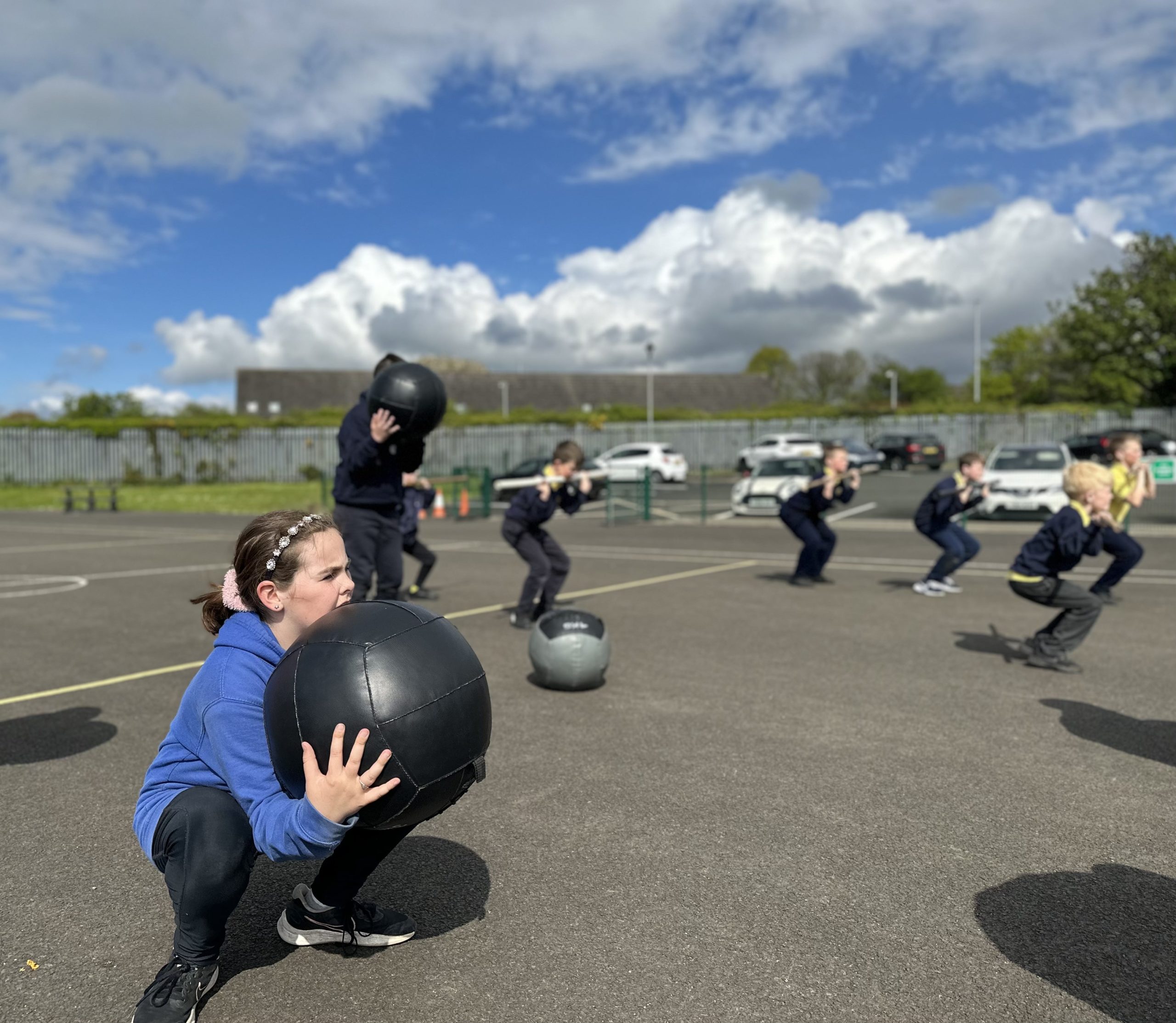 Limavady Central Primary School student squats with a medicine ball