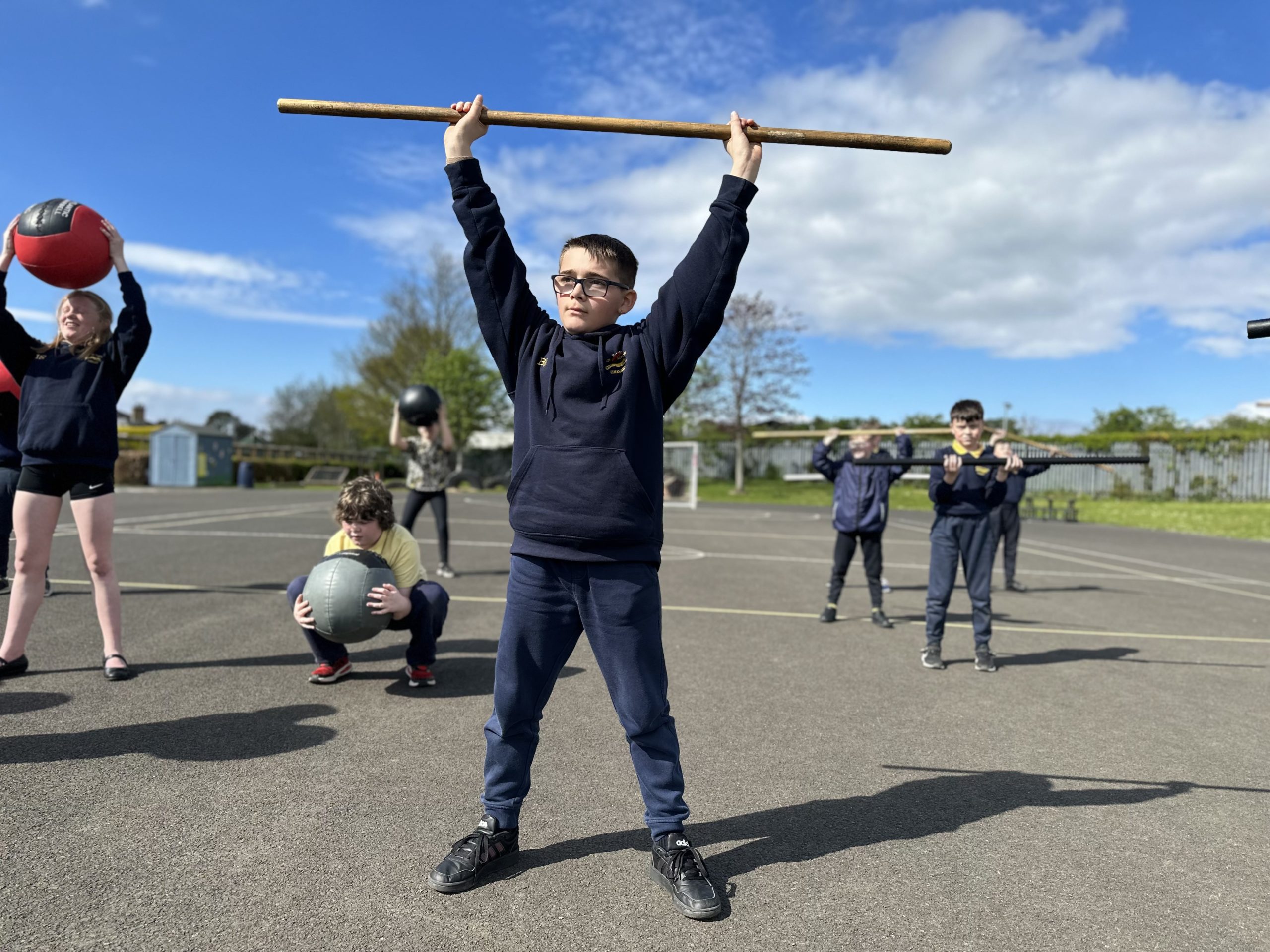 A Limavady Central Primary School student holds a dowel overhead