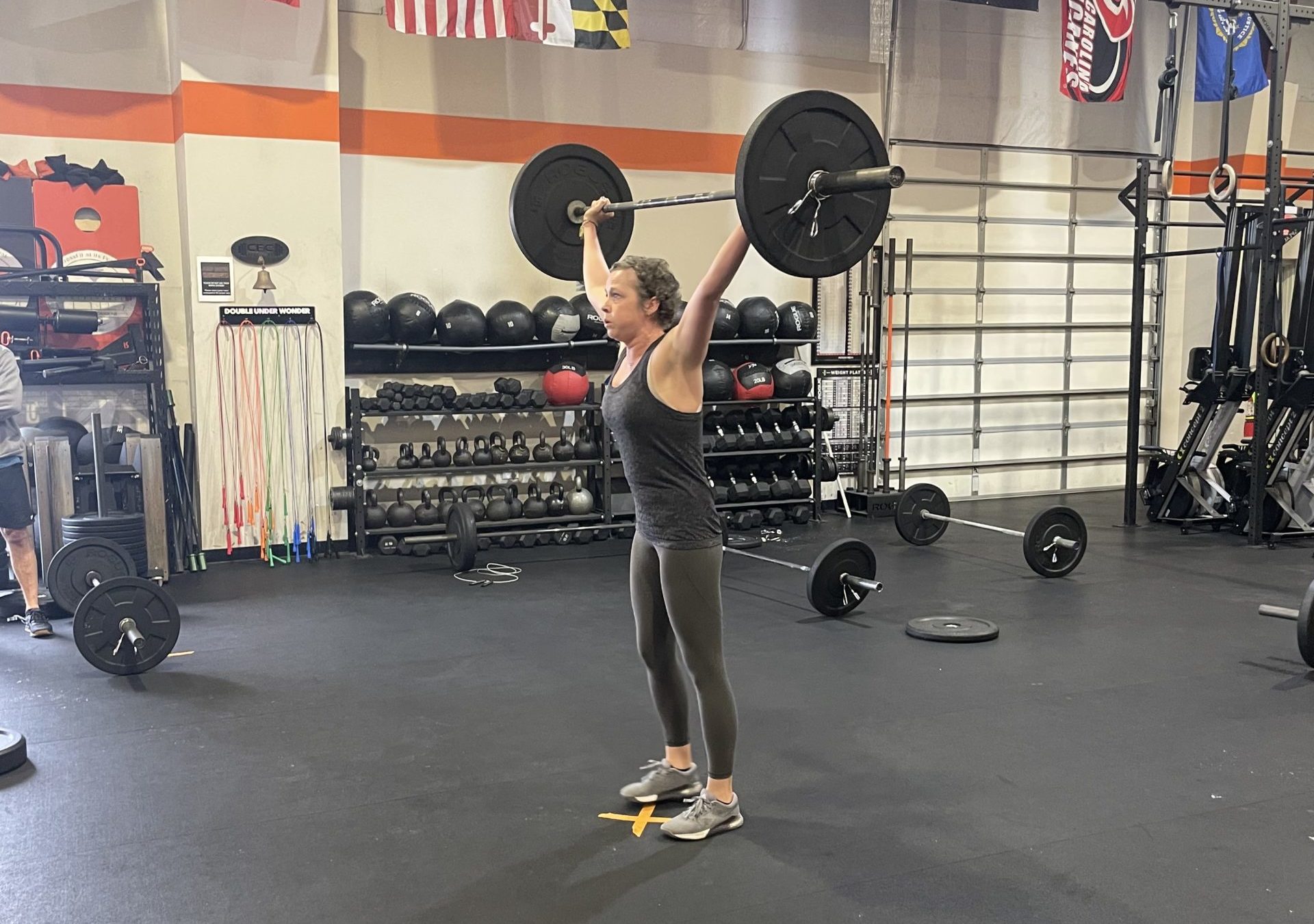 Erika Ryerson holds a barbell overhead.