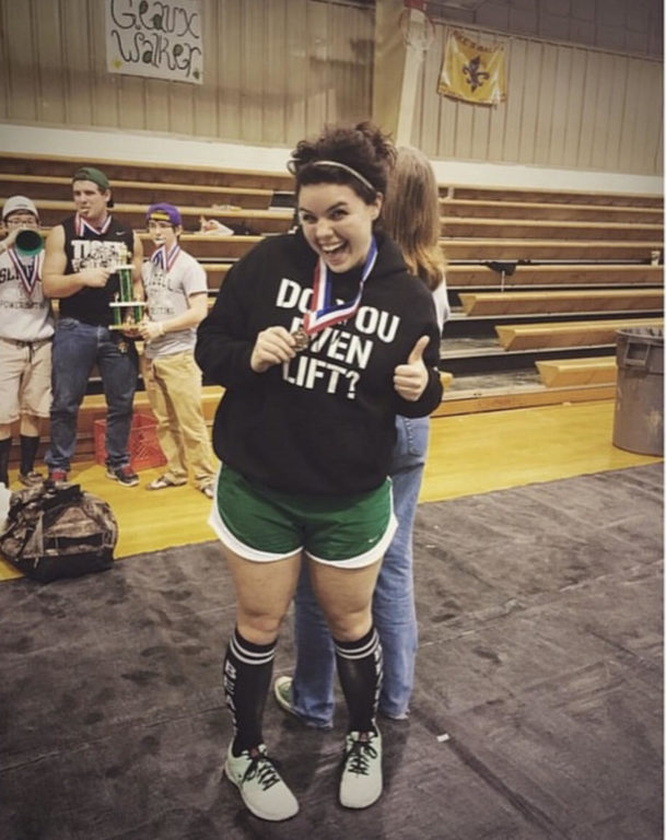 Taylor Heim showing off a first-place medal at a regional powerlifting competition