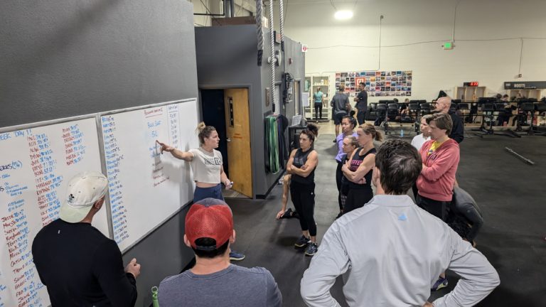 Picture of large group at a whiteboard at a CrossFit class