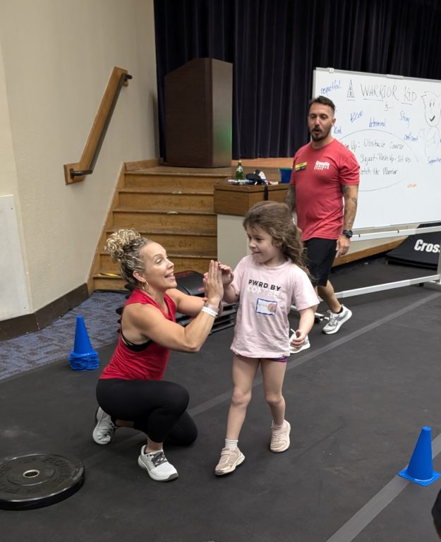 image of CrossFit kids coach Aimee Lyons high five CrossFit kid