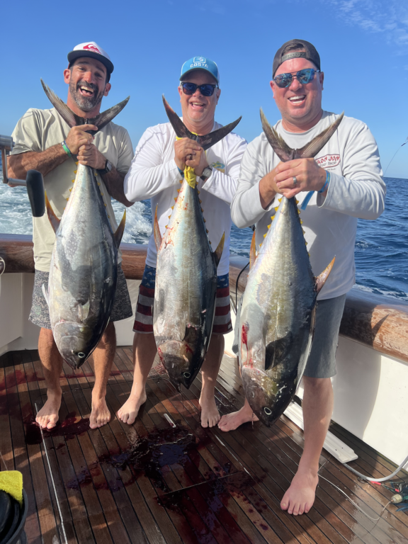 Luis Vela holding up a fish with two of his friends