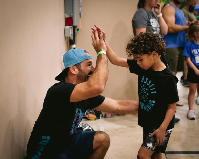 Luis Vela high fiving a kid at CrossFit Groundbreakers