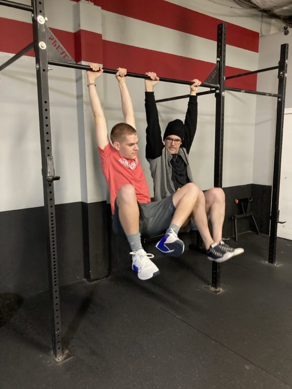 Chad Svoboda and Spencer Michaelsen hanging from a bar